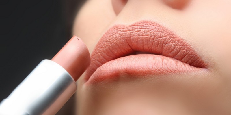 Frau trgt Lippenstift auf